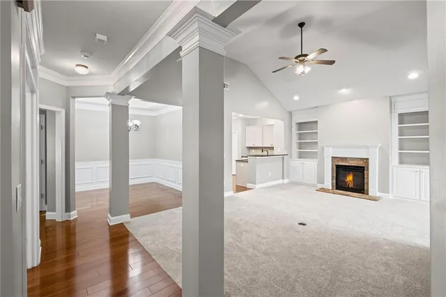 a view of a hallway with wooden floor and a kitchen