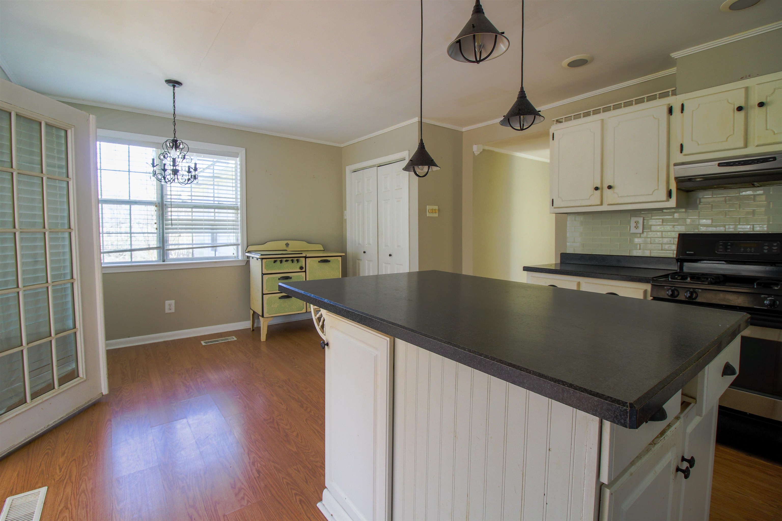 143 Marys Chapel Road Ripley, TN 38063 - Photo 5 of 23 Kitchen featuring gas range, white cabinets, dark countertops, tasteful backsplash, and dark wood-style floors