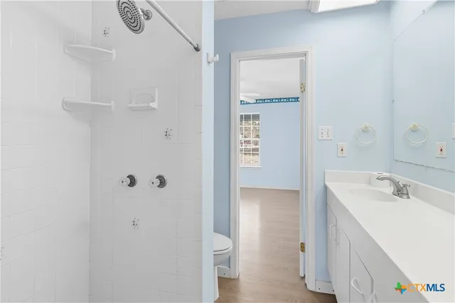 a bathroom with a sink a toilet and shower