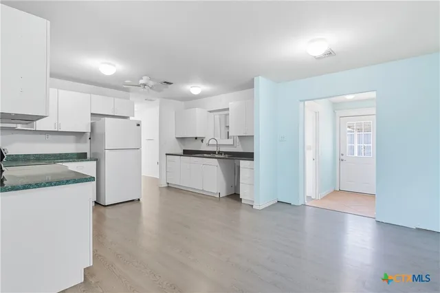 a kitchen with a refrigerator and a stove top oven
