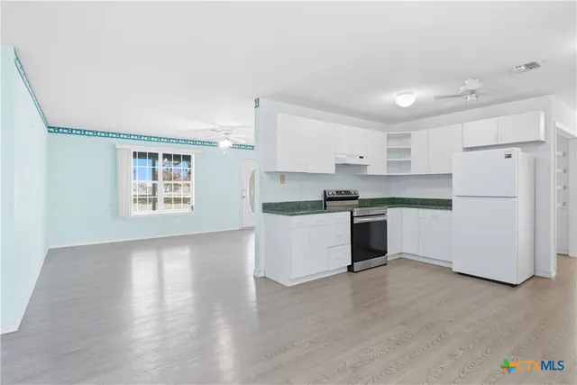 a kitchen with granite countertop white cabinets and white appliances