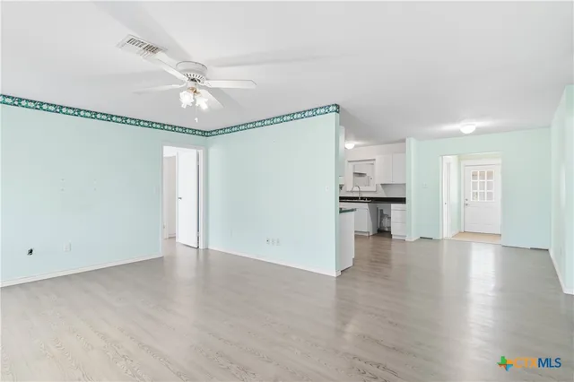 wooden floor in an empty room with a kitchen