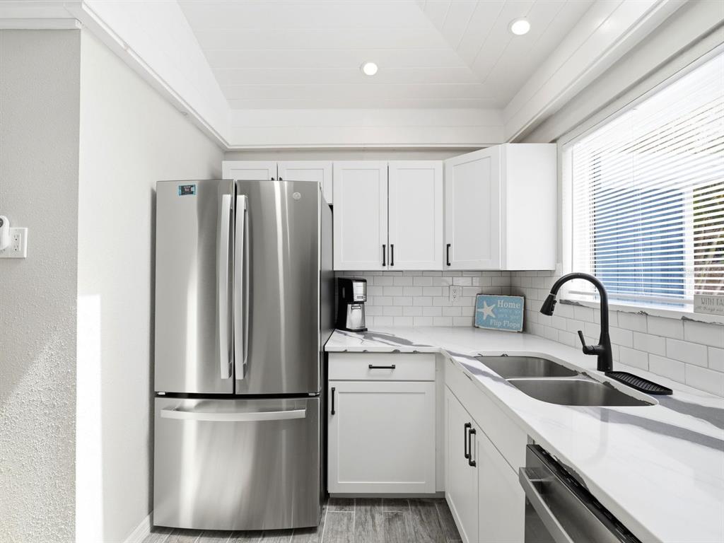 1207 1st Street Indian Rocks Beach, FL 33785 - Photo 14 of 60 a kitchen with a refrigerator sink and white cabinets