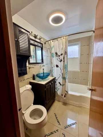 a bathroom with a granite countertop toilet sink and mirror