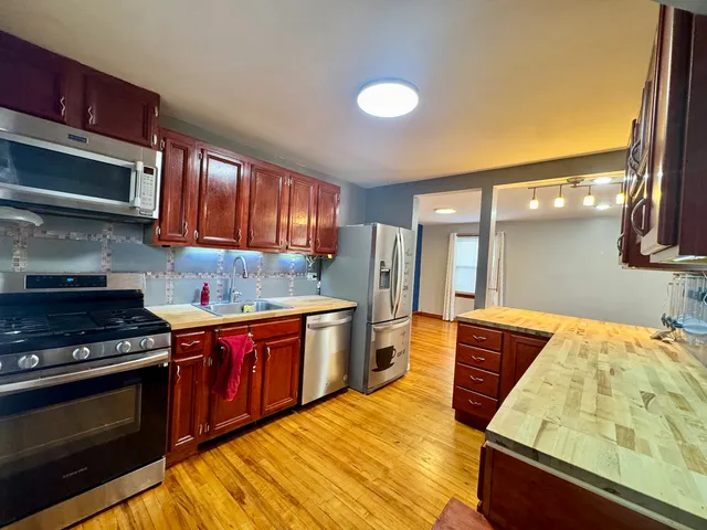 a kitchen with stainless steel appliances granite countertop a stove a sink and a microwave
