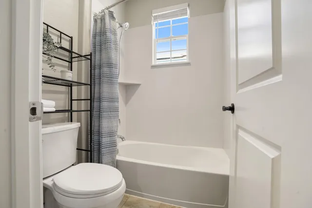 a bathroom with a toilet and a shower