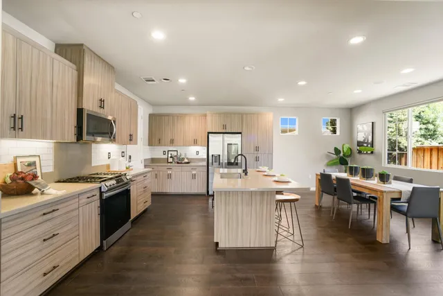 a kitchen with stainless steel appliances granite countertop wooden floors and view living room