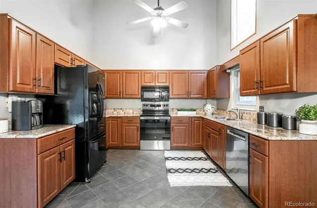 a kitchen with stainless steel appliances kitchen island granite countertop a stove sink and cabinets