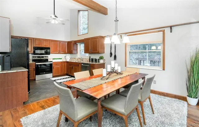a dining room with a table chairs and a kitchen view