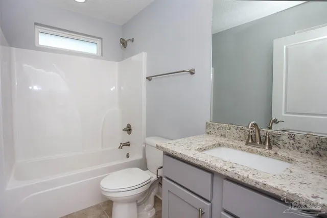 a bathroom with a granite countertop sink a toilet and shower