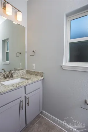 a bathroom with a granite countertop sink and a mirror