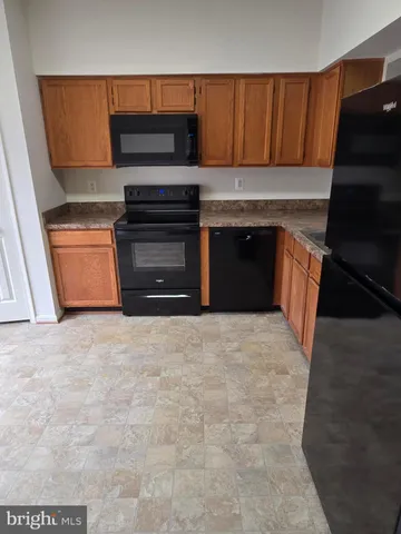 a kitchen with a refrigerator and a stove top oven
