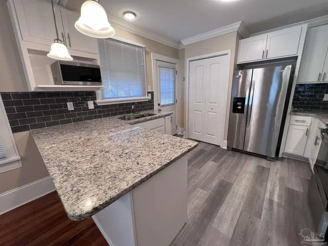 a kitchen with stainless steel appliances granite countertop a sink refrigerator and microwave