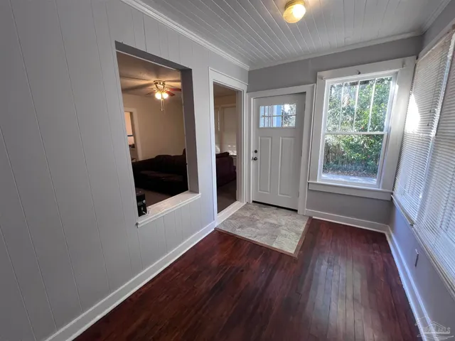 a view of hallway with window and wooden floor