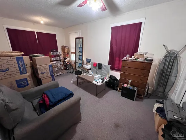 a living room with furniture a flat screen tv and a window