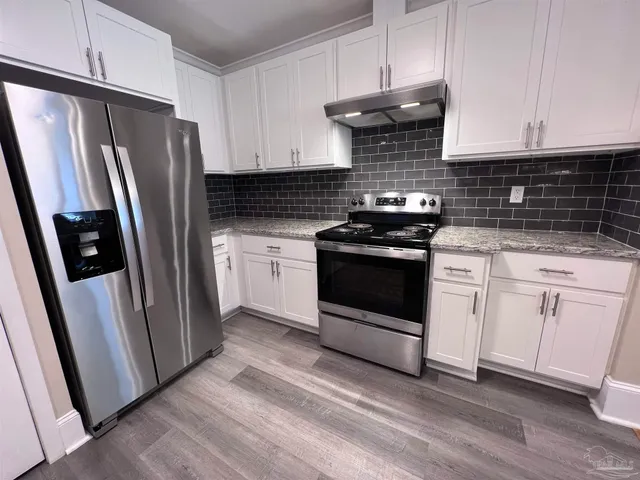 a kitchen with white cabinets and white appliances