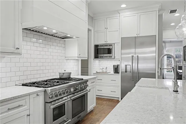 a kitchen with stainless steel appliances granite countertop a stove a refrigerator and a sink