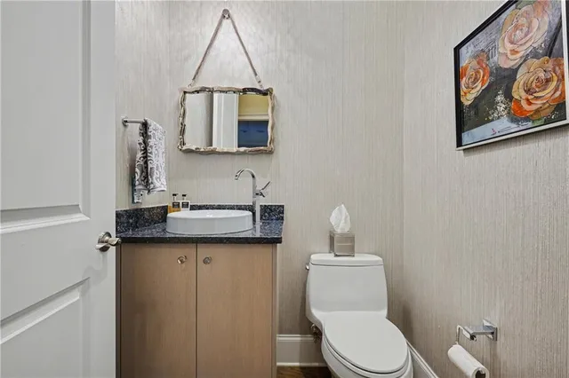 a bathroom with a toilet sink and mirror