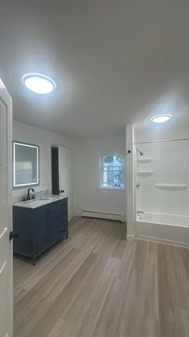 a view of an empty room and a kitchen