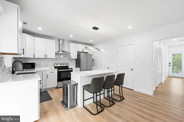 a kitchen with a table chairs microwave and cabinets