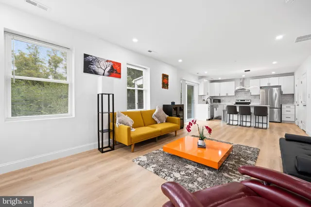 a kitchen with stainless steel appliances granite countertop a table chairs sink and cabinets