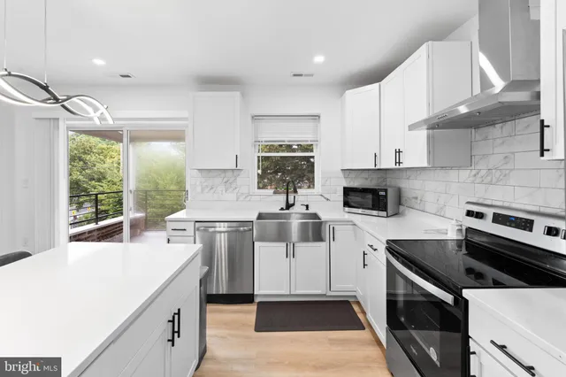 a view of a kitchen with kitchen island a living room and a window