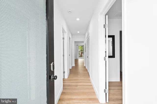 a view of a hallway with wooden floor