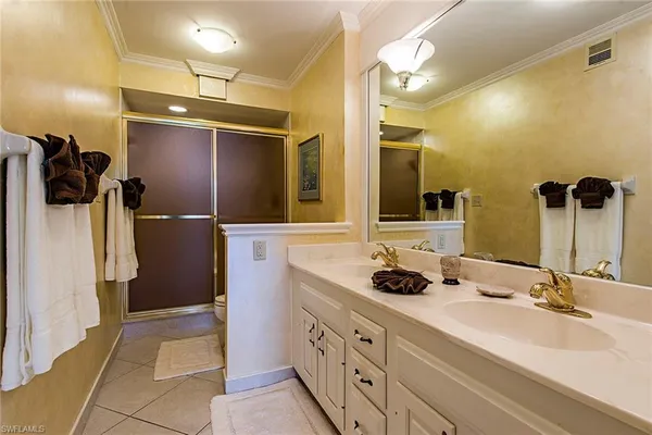 a bathroom with a double vanity sink a mirror and shower