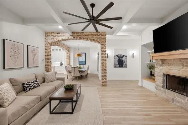 a living room with furniture a flat screen tv and a fireplace