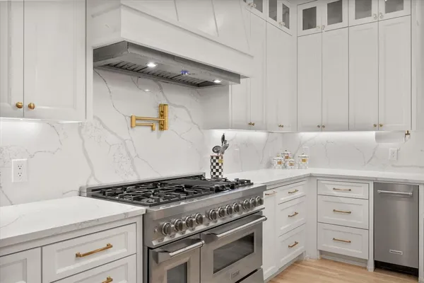 a kitchen with a stove and white cabinets