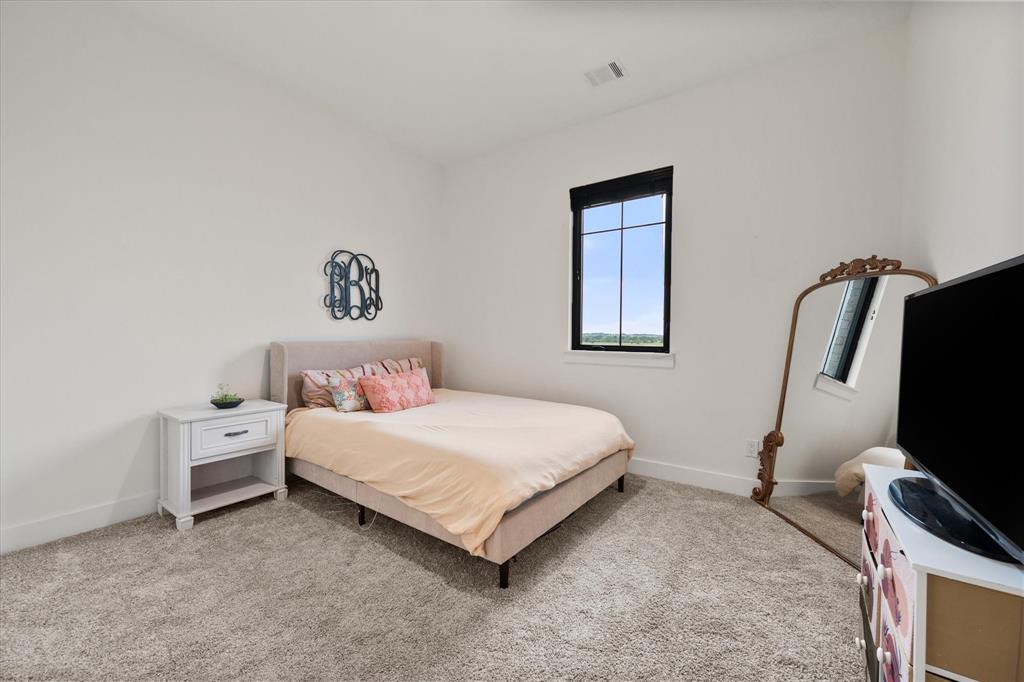 1911 Ozro Road Venus, TX 76084 - Photo 27 of 40 a bedroom with a bed and a flat screen tv