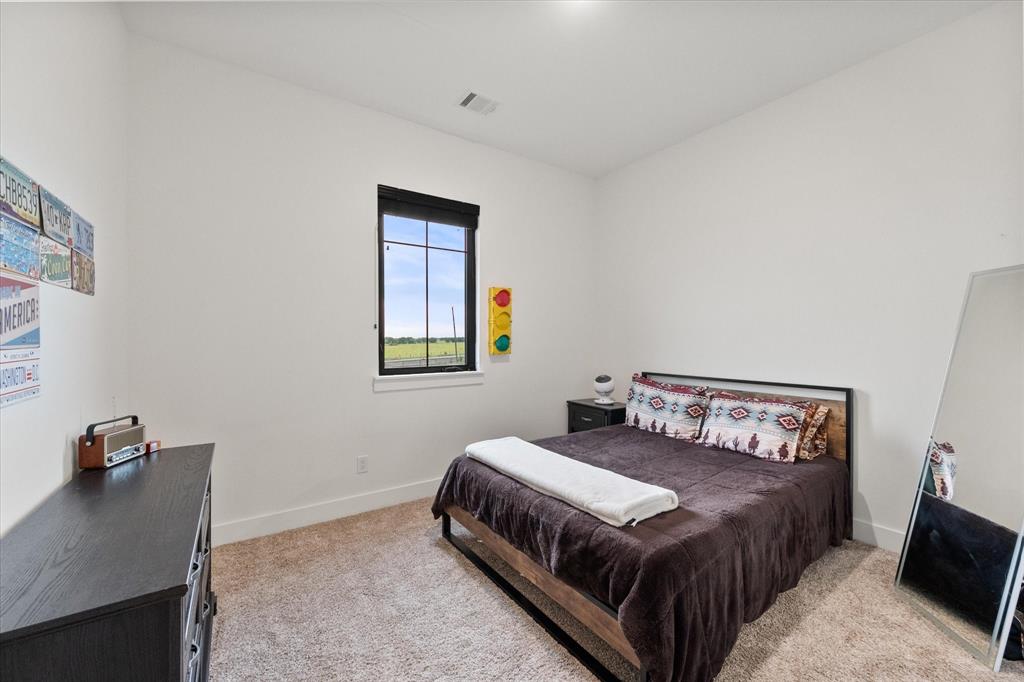 1911 Ozro Road Venus, TX 76084 - Photo 29 of 40 a bedroom with a bed and wooden floor