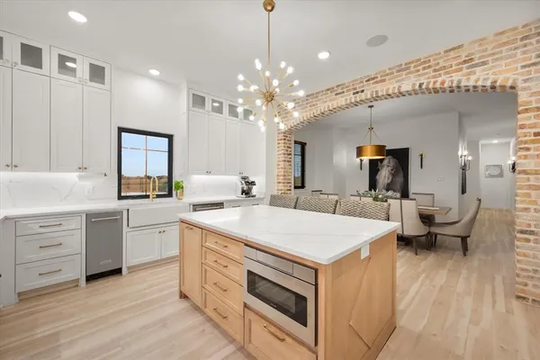 a kitchen that has a lot of white cabinets and couches