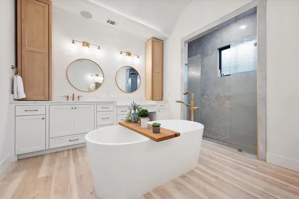a bathroom with a bathtub a sink and a mirror