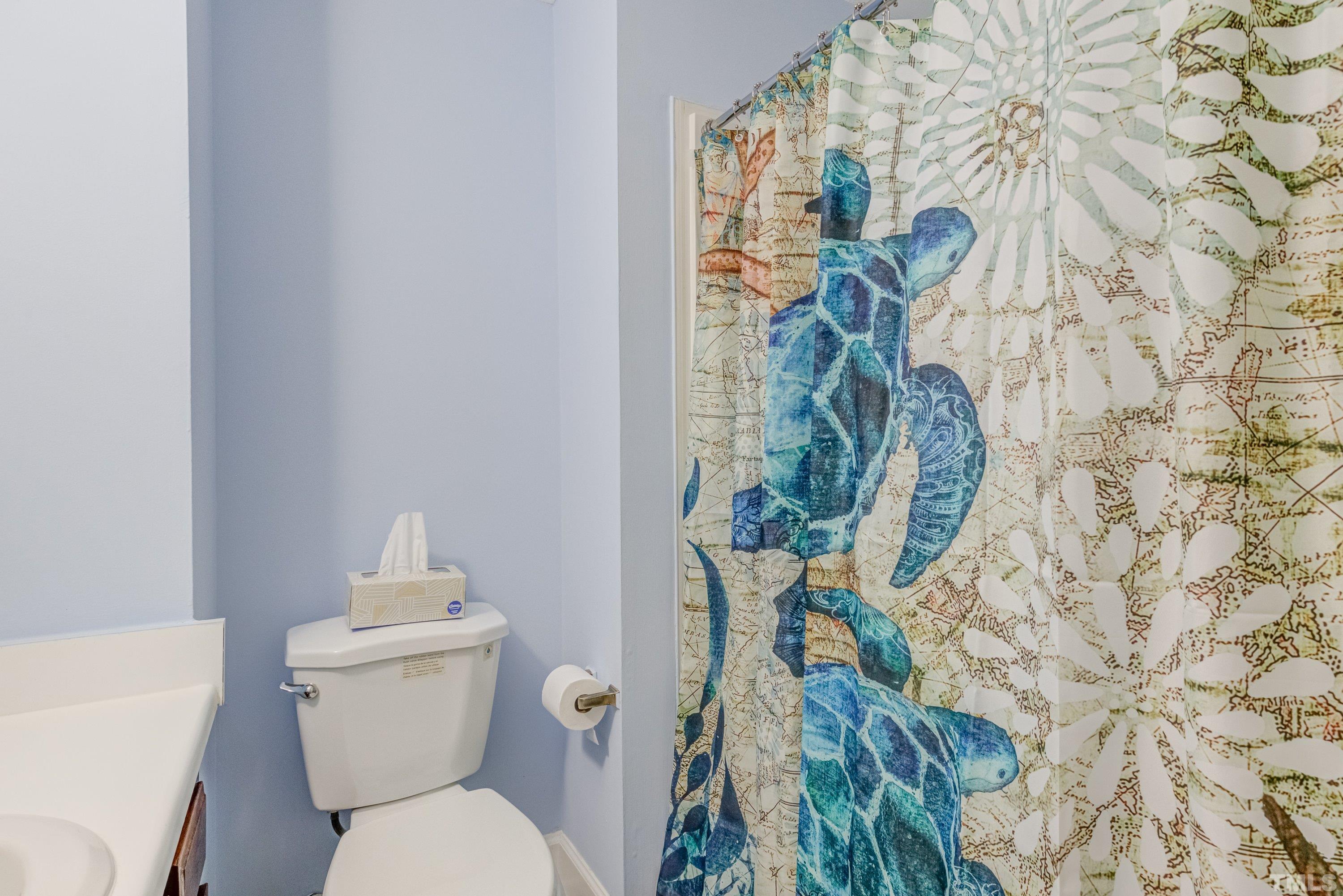 7921 Mourning Dove Road Raleigh, NC 27615 - Photo 34 of 52 a bathroom with a toilet and a shower curtain