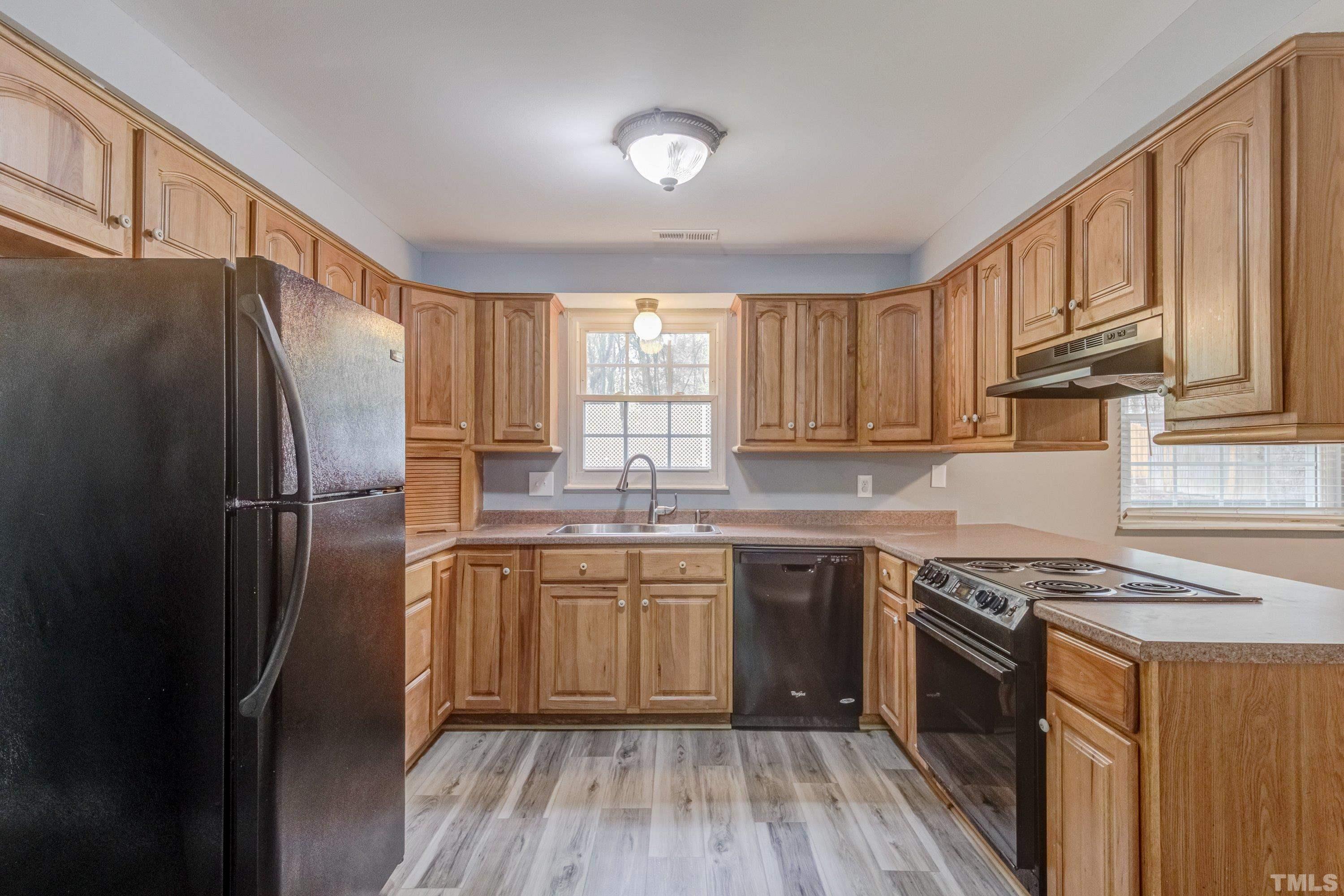 7921 Mourning Dove Road Raleigh, NC 27615 - Photo 5 of 52 a kitchen with stainless steel appliances granite countertop a refrigerator a sink dishwasher a stove and white countertops with wooden floor