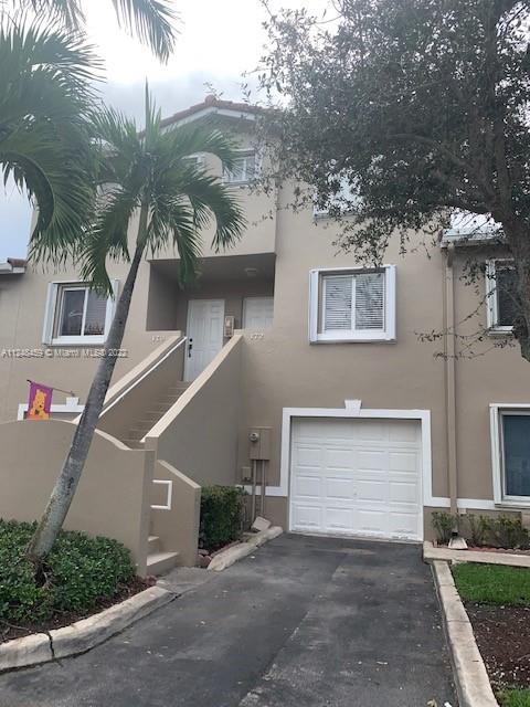219 Riviera Circle, Unit 219 Weston, FL 33326 - Photo 1 of 22 a front view of a house with a yard and garage