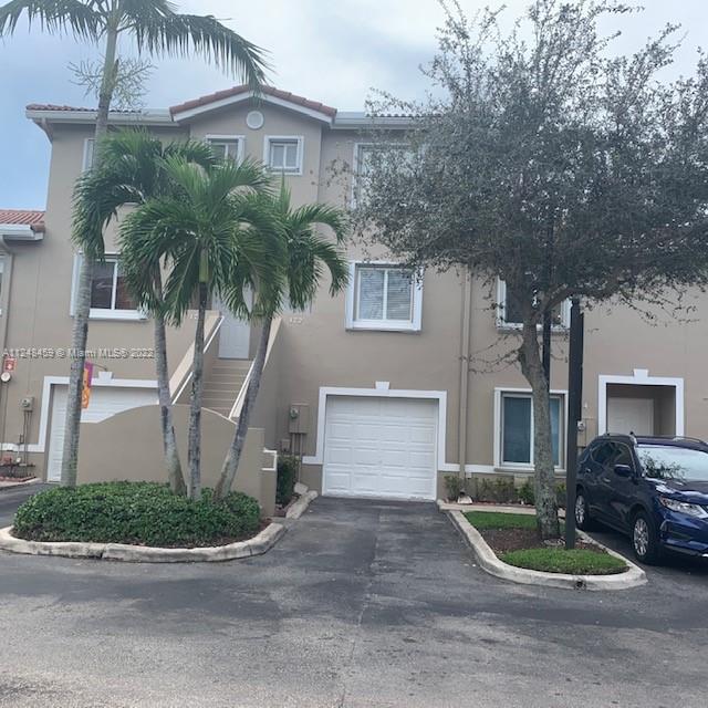 219 Riviera Circle, Unit 219 Weston, FL 33326 - Photo 20 of 22 a front view of a house with a yard and garage