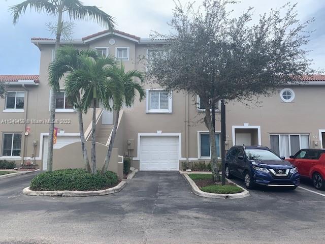 219 Riviera Circle, Unit 219 Weston, FL 33326 - Photo 21 of 22 a front view of a house with garden and parking