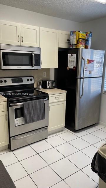219 Riviera Circle, Unit 219 Weston, FL 33326 - Photo 5 of 22 a kitchen with stainless steel appliances a stove a microwave and a refrigerator