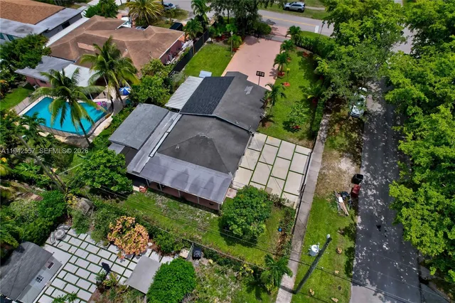 an aerial view of residential houses with outdoor space and trees