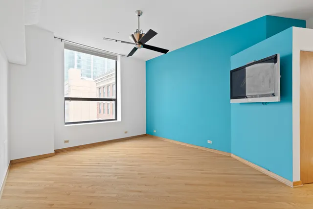 a view of empty room with window and ceiling fan