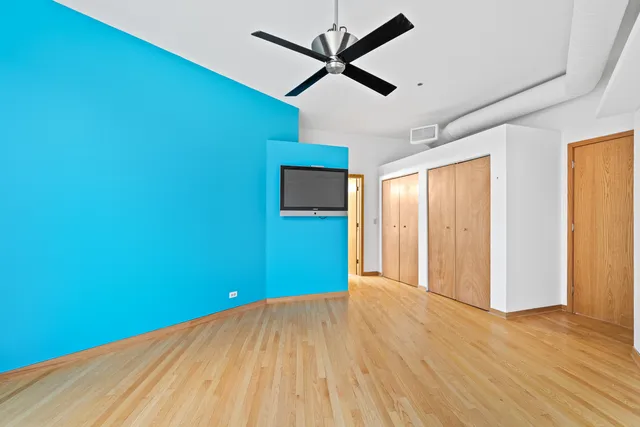 a view of a big room with wooden floor and windows