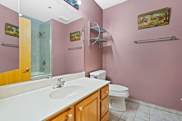 a bathroom with a granite countertop sink mirror vanity and toilet