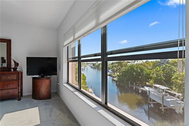 a view of a livingroom with furniture a flat screen tv and floor to ceiling window