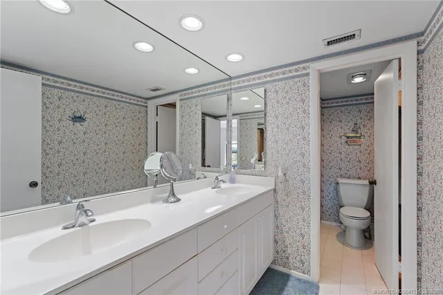 a bathroom with a double vanity sink mirror and shower