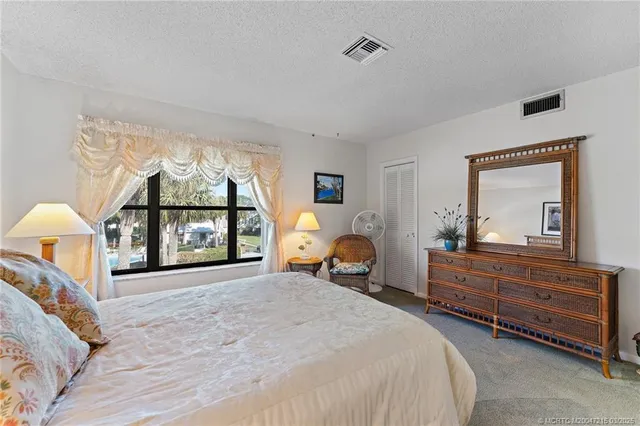a bedroom with a bed window and dresser