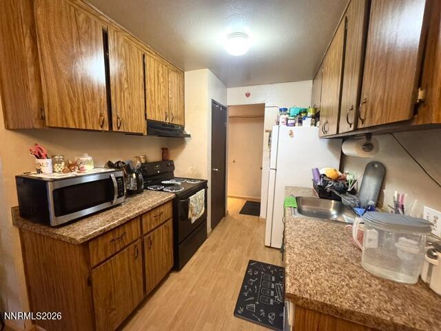 1557 Delucchi Lane, Unit G Reno, NV 89502 - Photo 3 of 8 a kitchen with stainless steel appliances granite countertop a sink stove and refrigerator