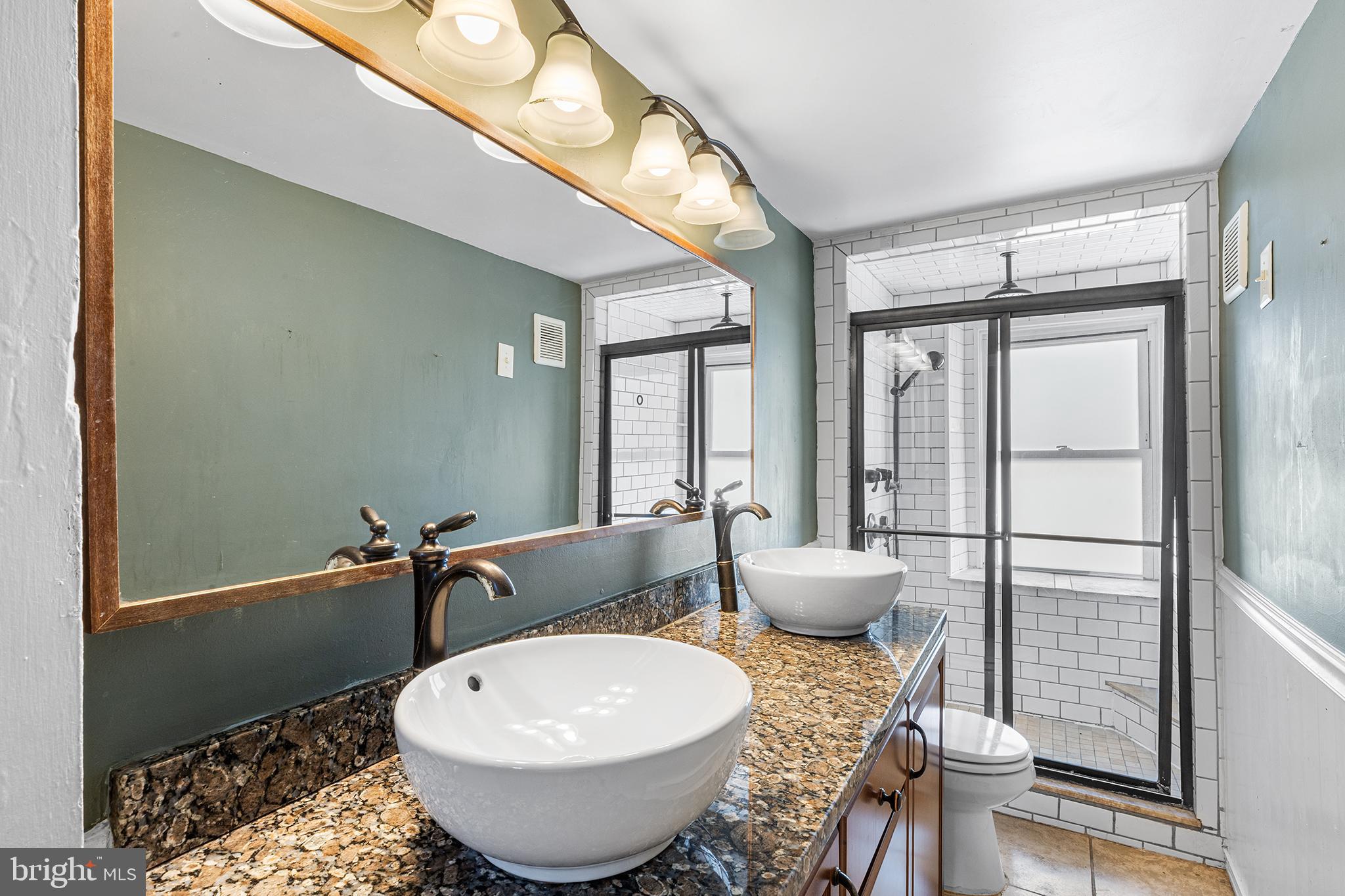 157 Cotton Street Philadelphia, PA 19127 - Photo 14 of 26 a bathroom with a granite countertop sink and a mirror