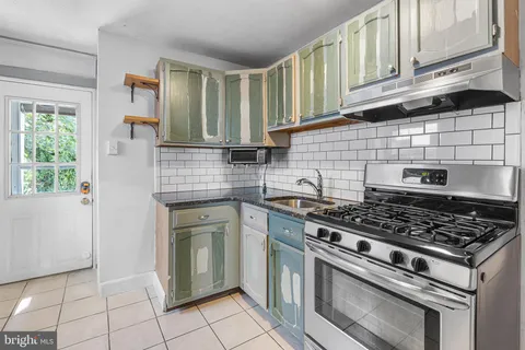 a kitchen with granite countertop a stove sink and cabinets
